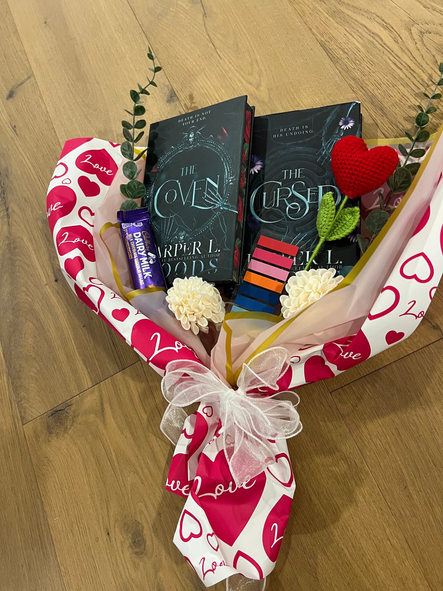 Gift basket with dark romance books, chocolates, and flowers